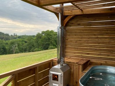 Hébergement insolite en Aquitaine : cabane en bois avec baignoire et poêle à bois.