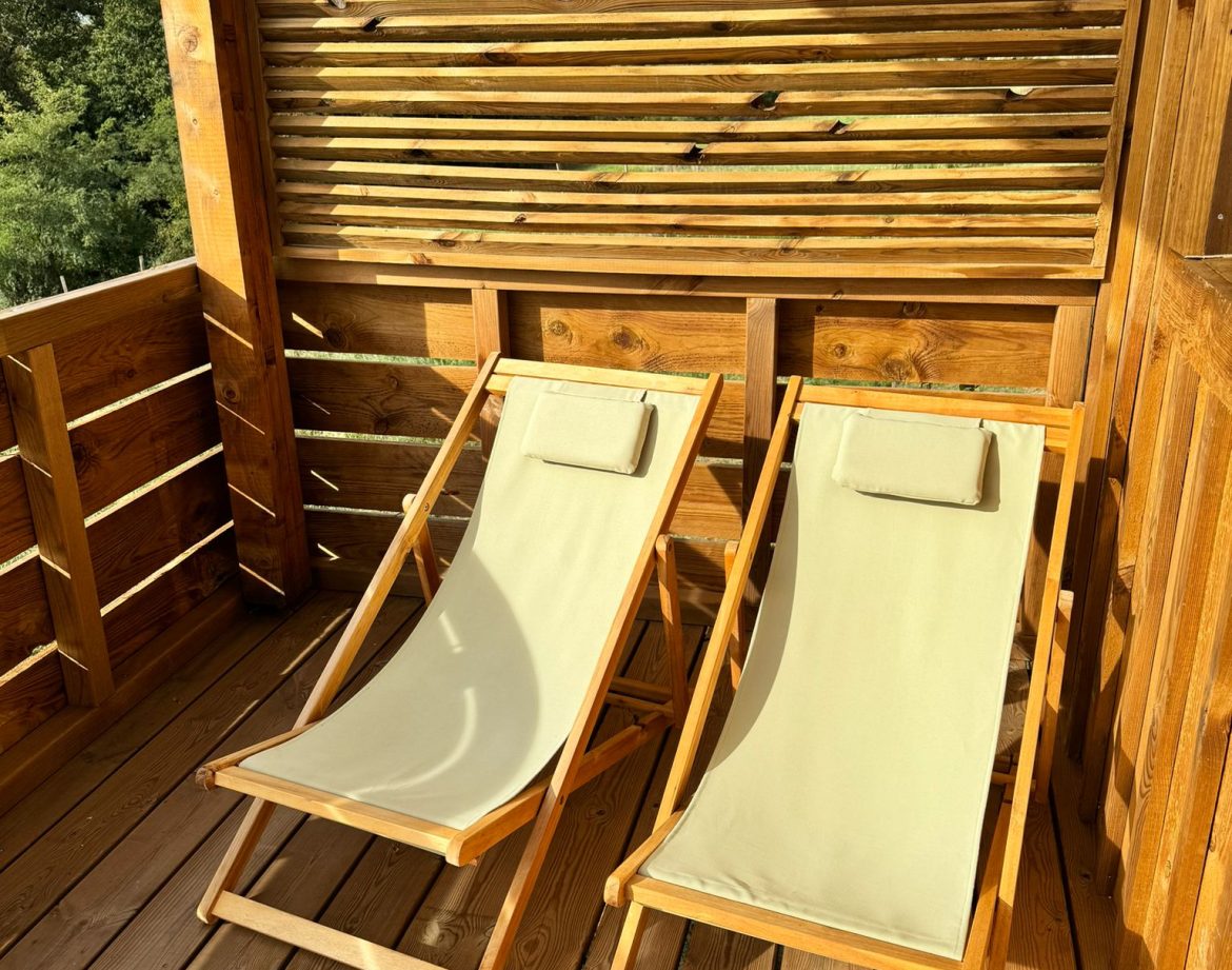 Chalet en bois avec chaises longues sur une terrasse ensoleillée en Aquitaine.