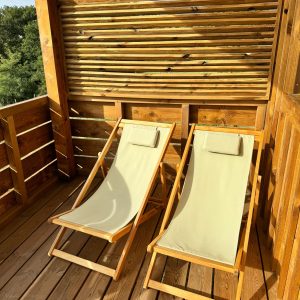 Chalet en bois avec chaises longues sur une terrasse ensoleillée en Aquitaine.