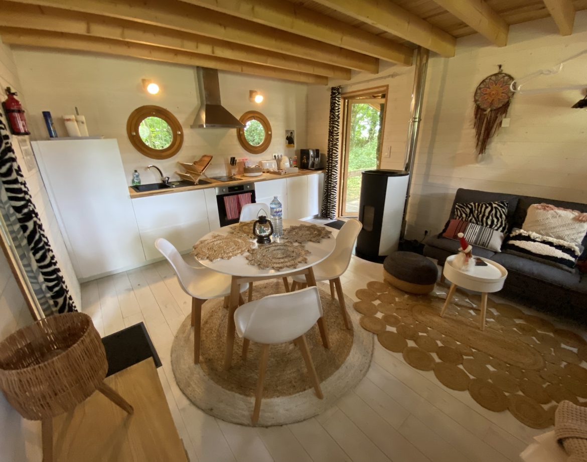 Hébergement insolite en Bretagne : chalet moderne avec cuisine ouverte et décoration chaleureuse.