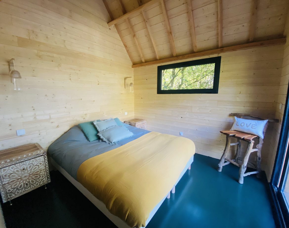 Chalet en bois lumineux en Bretagne, avec un lit douillet et vue sur la nature.