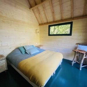 Chalet en bois lumineux en Bretagne, avec un lit douillet et vue sur la nature.