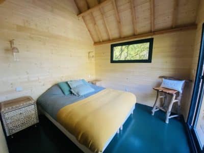 Chalet en bois lumineux en Bretagne, avec un lit douillet et vue sur la nature.