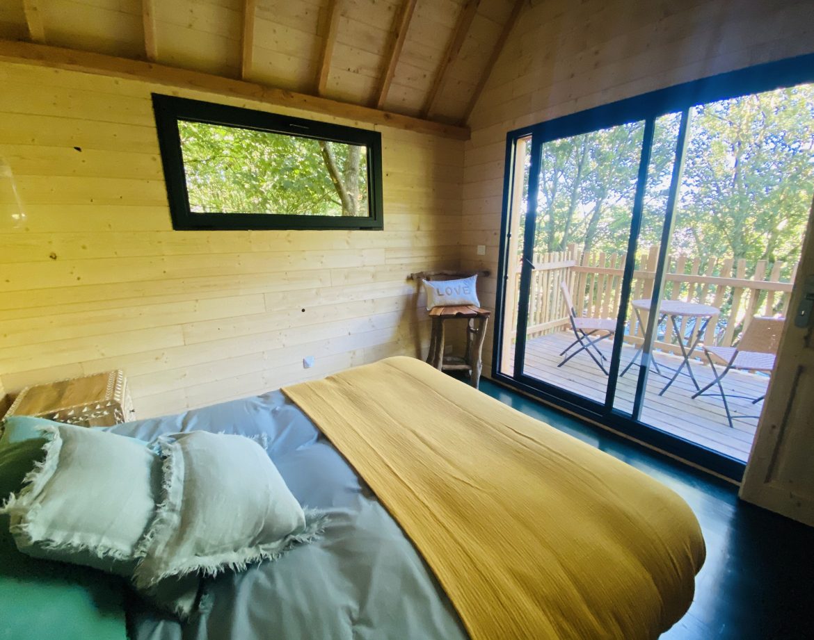 Cabane en bois en Bretagne, avec un lit douillet et une vue sur la nature.