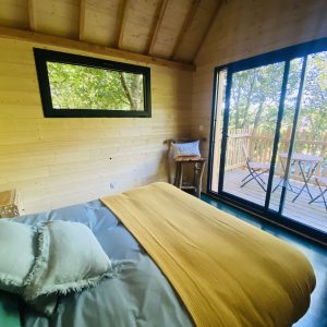 Cabane en bois en Bretagne, avec un lit douillet et une vue sur la nature.
