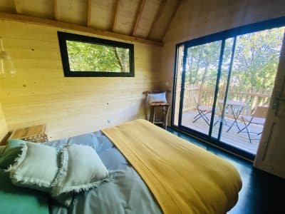 Cabane en bois en Bretagne, avec un lit douillet et une vue sur la nature.