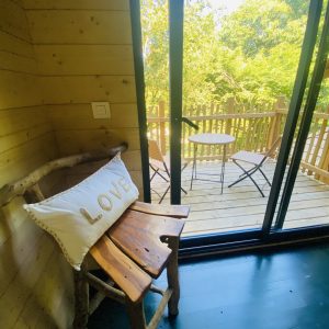 Cabane en bois en Bretagne, avec un balcon et un coussin décoratif LOVE.