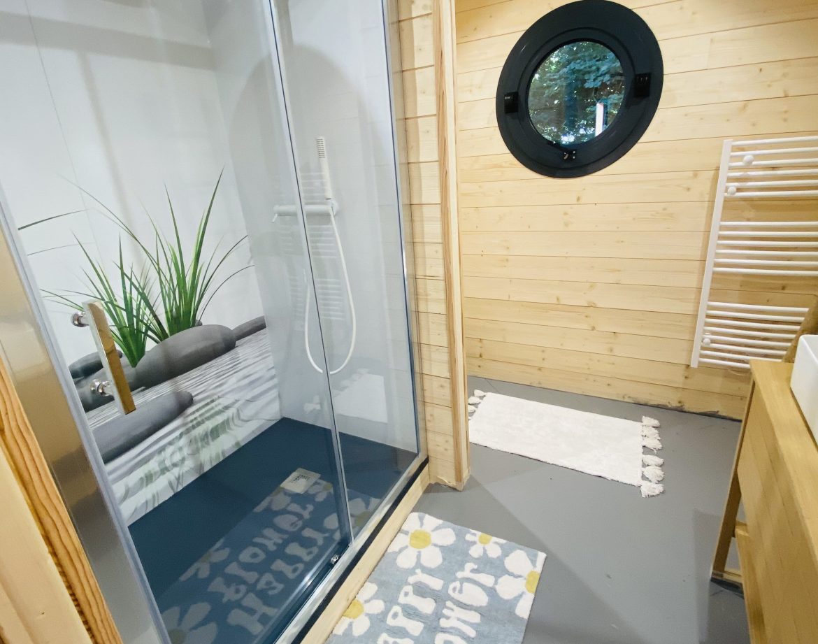 Cabane en bois en Bretagne avec douche moderne et décoration florale.