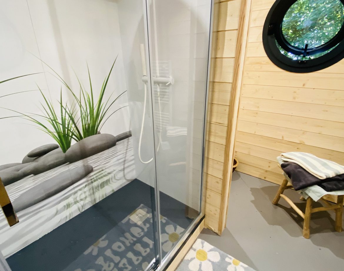 Douche moderne dans un hébergement insolite en Bretagne, avec un décor en bois chaleureux.