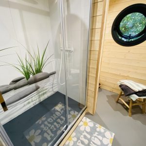 Douche moderne dans un hébergement insolite en Bretagne, avec un décor en bois chaleureux.