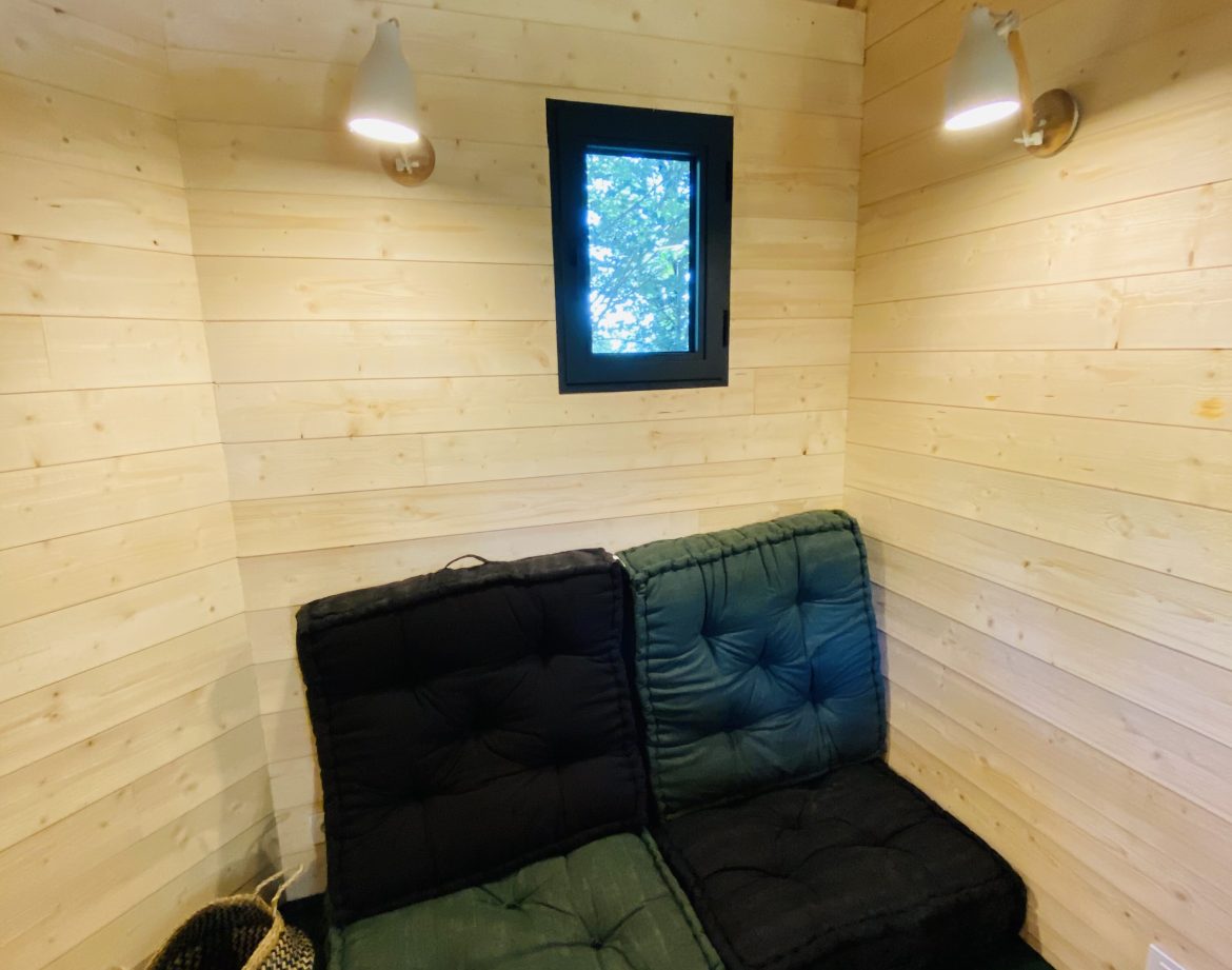 Hébergement insolite en Bretagne : intérieur en bois avec un coin salon confortable.