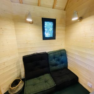 Hébergement insolite en Bretagne : intérieur en bois avec un coin salon confortable.