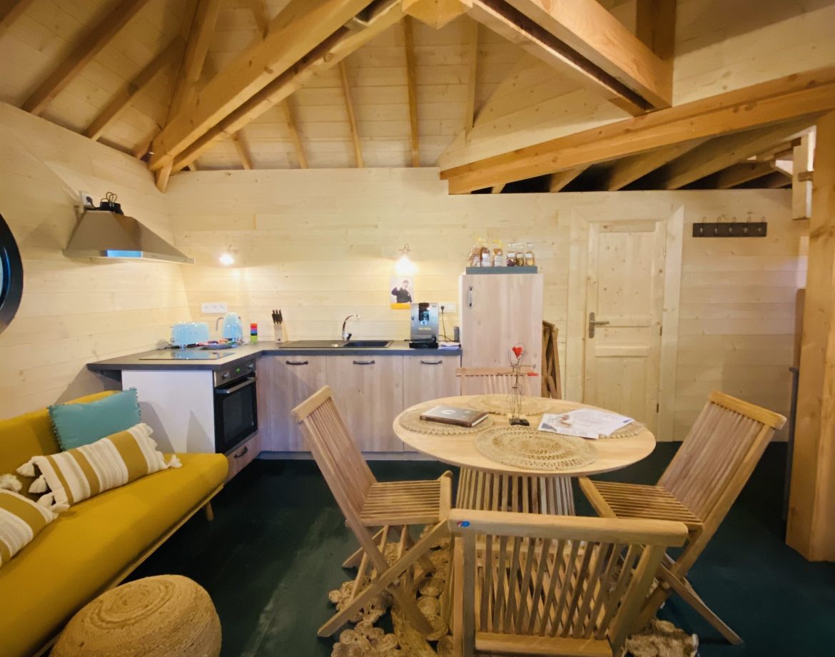Hébergement insolite en Bretagne : chalet en bois avec cuisine moderne et salon cosy.
