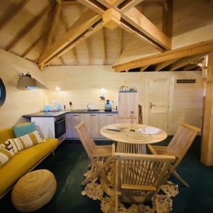 Hébergement insolite en Bretagne : chalet en bois avec cuisine moderne et salon cosy.