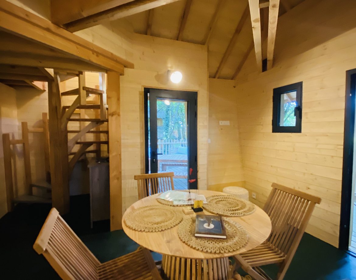 Hébergement insolite en Bretagne : cabane en bois avec un coin repas chaleureux.