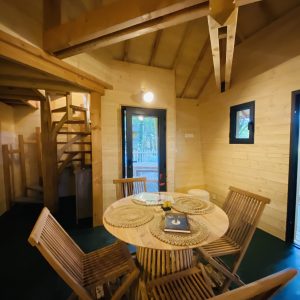 Hébergement insolite en Bretagne : cabane en bois avec un coin repas chaleureux.