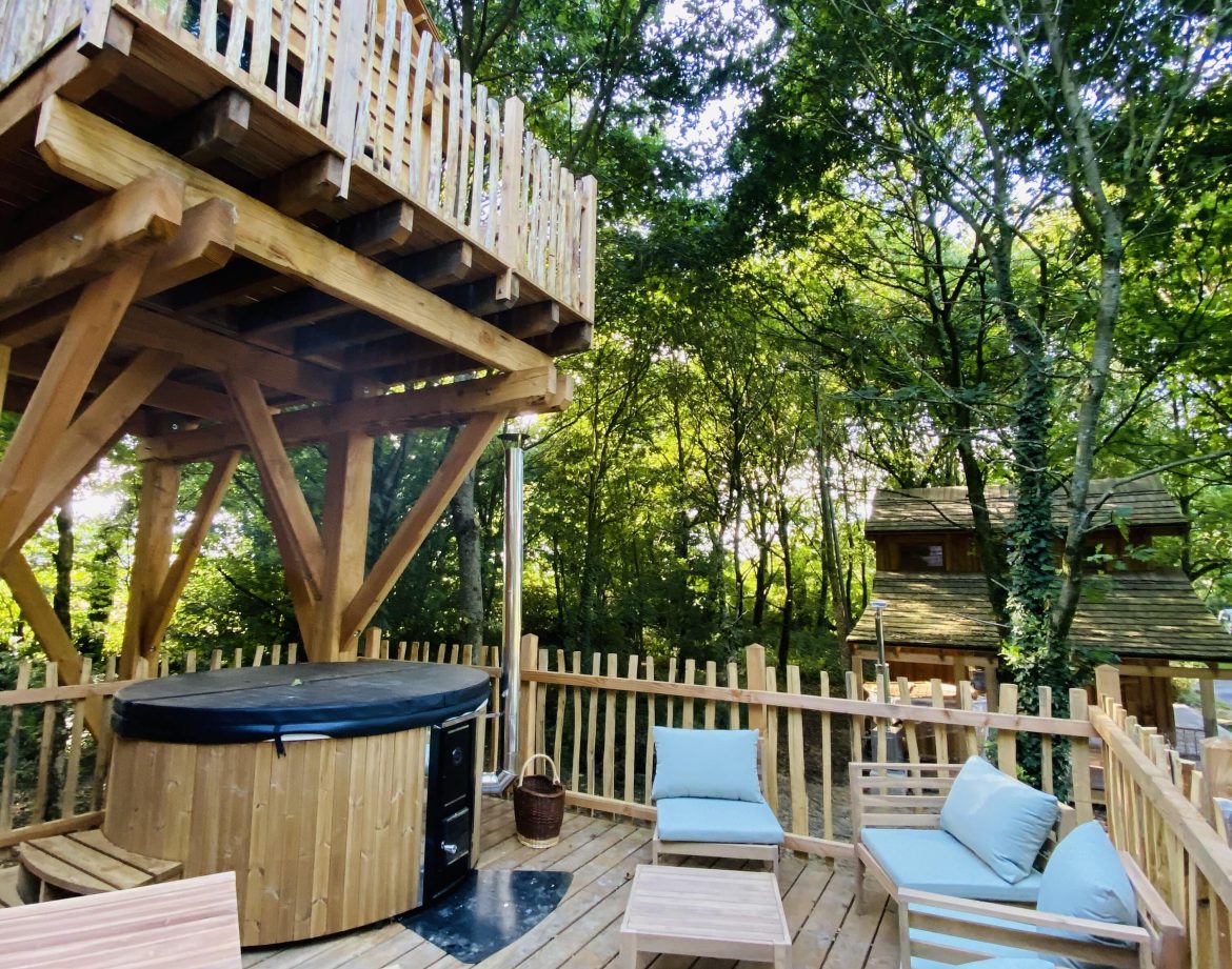 Cabane perchée en Bretagne avec jacuzzi et coin détente en bois.