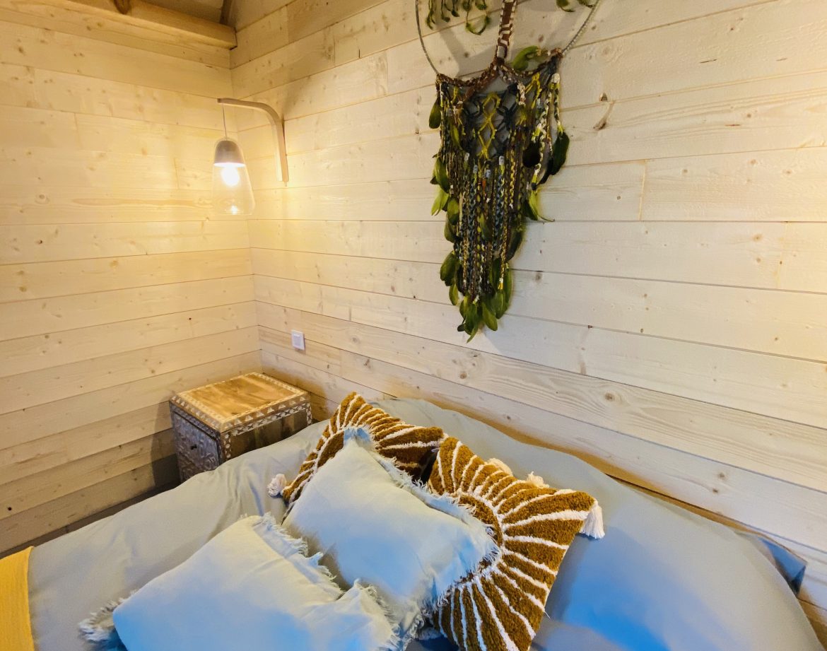 Chalet en bois en Bretagne, avec une literie confortable et une décoration artisanale.