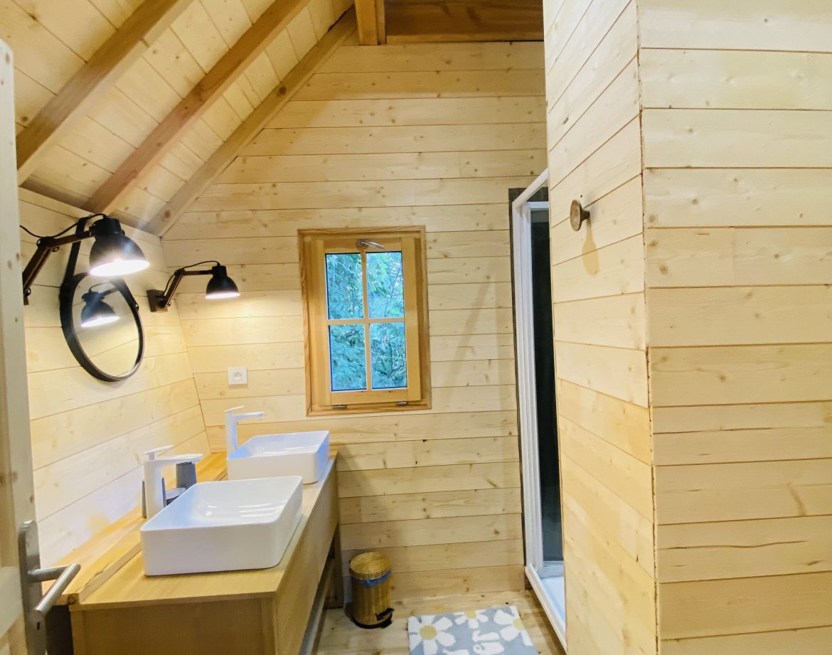 Cabane en bois en Bretagne avec salle de bain lumineuse et décor chaleureux.