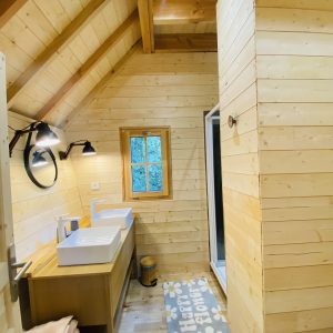 Cabane en bois en Bretagne avec salle de bain lumineuse et décor chaleureux.
