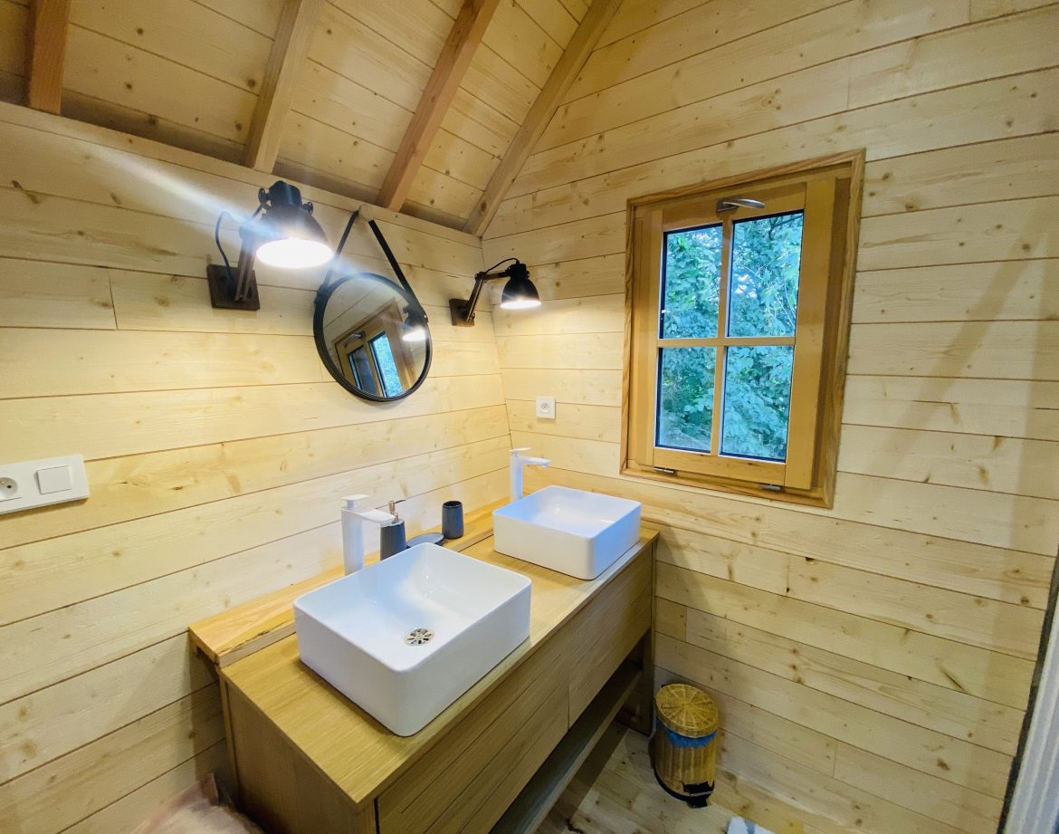 Salle de bain moderne dun chalet en bois en Bretagne, avec vasques élégantes.