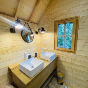 Salle de bain moderne dun chalet en bois en Bretagne, avec vasques élégantes.