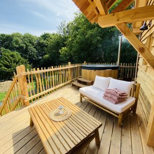 Cabane en bois en Bretagne avec terrasse en bois et jacuzzi extérieur.