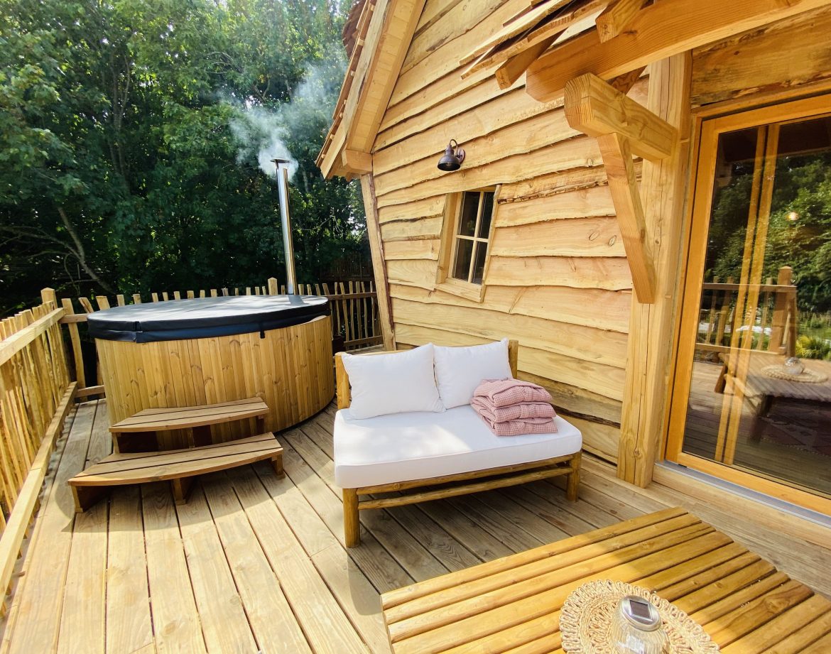 Cabane en bois en Bretagne avec jacuzzi sur la terrasse et coin détente.