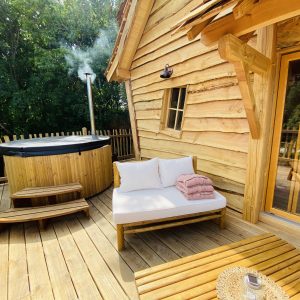 Cabane en bois en Bretagne avec jacuzzi sur la terrasse et coin détente.