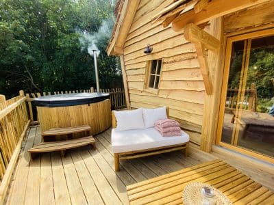 Cabane en bois en Bretagne avec jacuzzi sur la terrasse et coin détente.