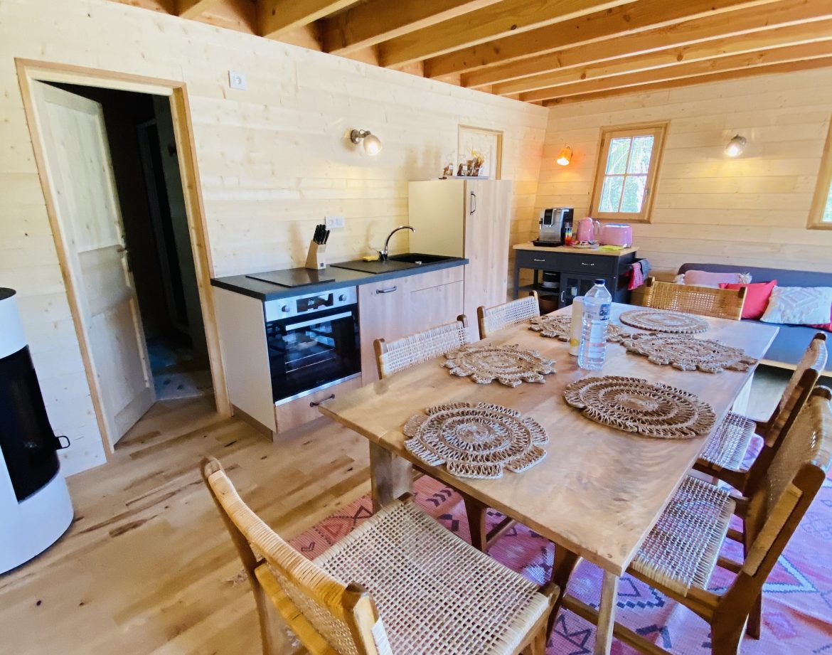 Hébergement insolite en Bretagne : chalet en bois avec cuisine et table en bois.