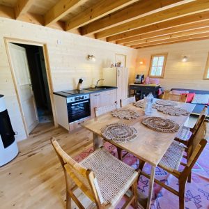 Hébergement insolite en Bretagne : chalet en bois avec cuisine et table en bois.