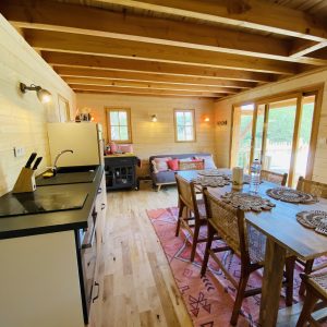 Cabane en bois en Bretagne, avec cuisine ouverte et décoration chaleureuse.