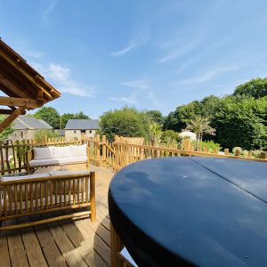 Hébergement insolite en Bretagne : cabane en bois avec terrasse et jacuzzi.
