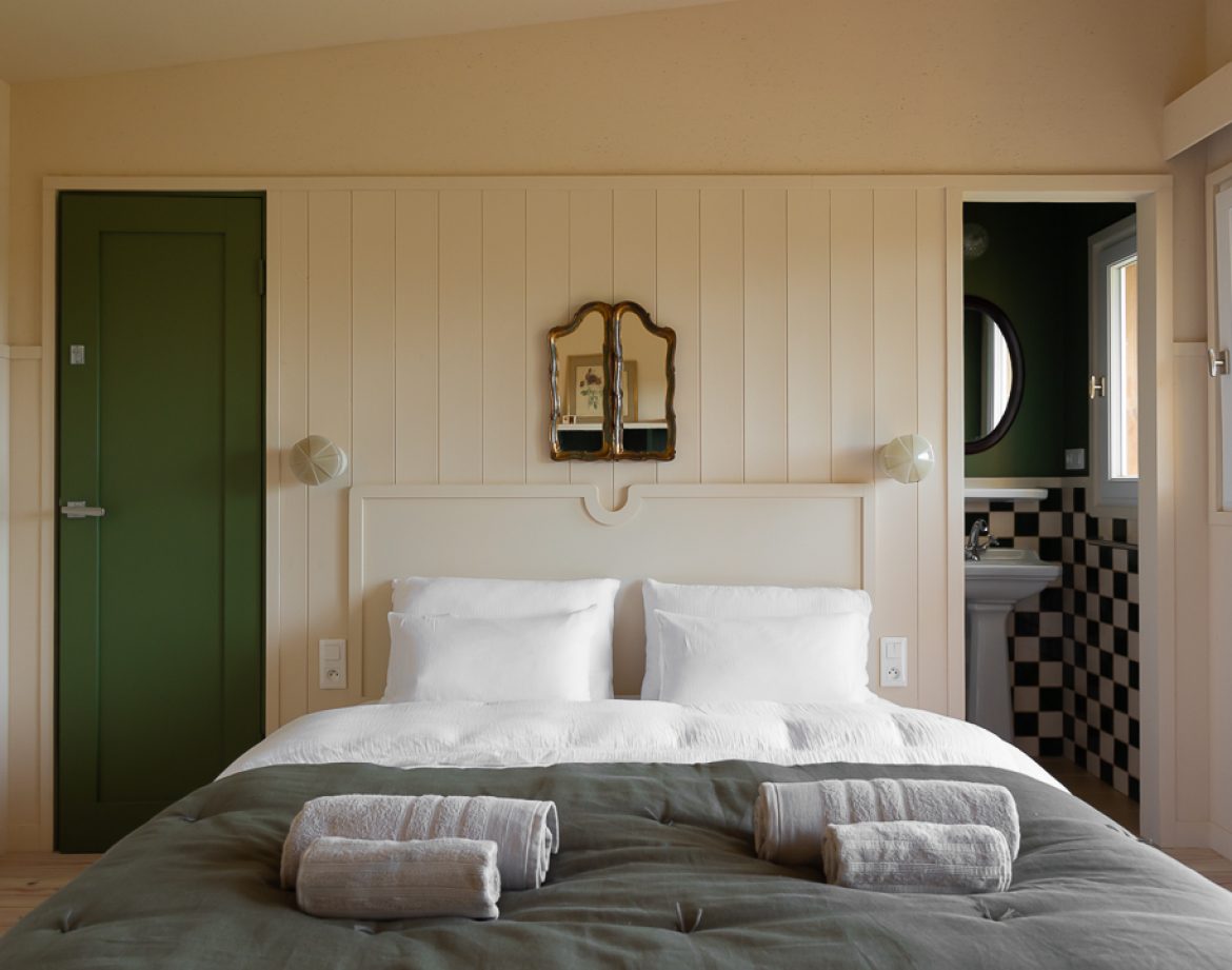 Chambre dhôtes moderne en Aquitaine, avec murs clairs et miroir vintage.