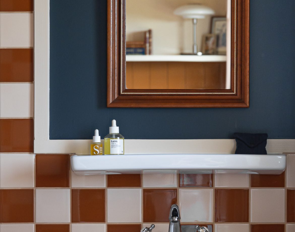 Salle de bain dun hébergement insolite en Aquitaine, carrelage bicolore élégant.
