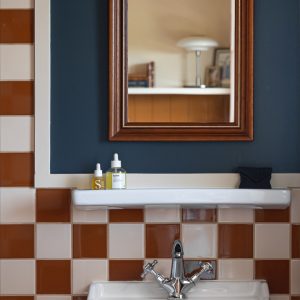 Salle de bain dun hébergement insolite en Aquitaine, carrelage bicolore élégant.