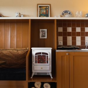 Hébergement insolite en Aquitaine : intérieur chaleureux avec poêle vintage et coin salon.