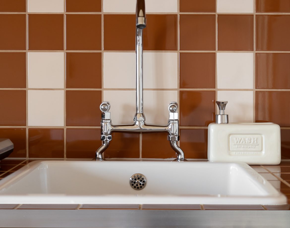 Évier vintage en céramique dans un hébergement insolite en Aquitaine. Décor chaleureux.