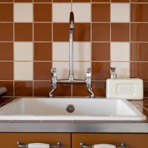 Évier vintage en céramique dans un hébergement insolite en Aquitaine. Décor chaleureux.