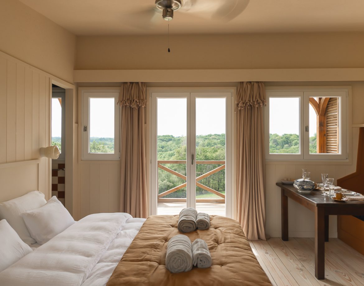 Chambre dhôtes perchée avec vue sur la nature, décor chaleureux et lumineux.