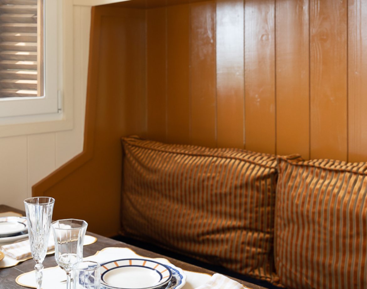 Hébergement insolite en Aquitaine : coin repas cosy avec vaisselle élégante et coussins.