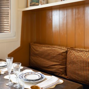 Hébergement insolite en Aquitaine : coin repas cosy avec vaisselle élégante et coussins.