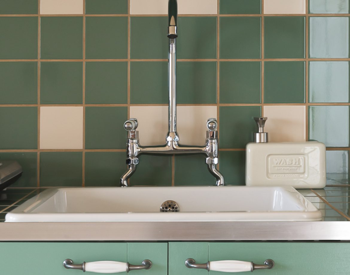 Élégante cuisine dun hébergement insolite en Aquitaine avec carrelage vert.