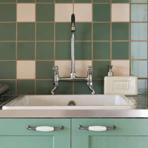 Élégante cuisine dun hébergement insolite en Aquitaine avec carrelage vert.