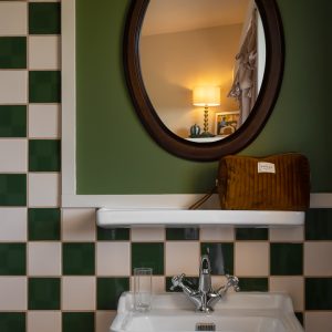 Hébergement insolite en Aquitaine : salle de bain vintage avec carrelage bicolore.