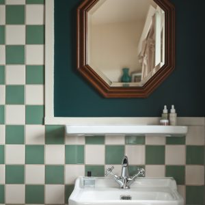 Salle de bain dun hébergement insolite en Aquitaine, carrelage bicolore élégant.