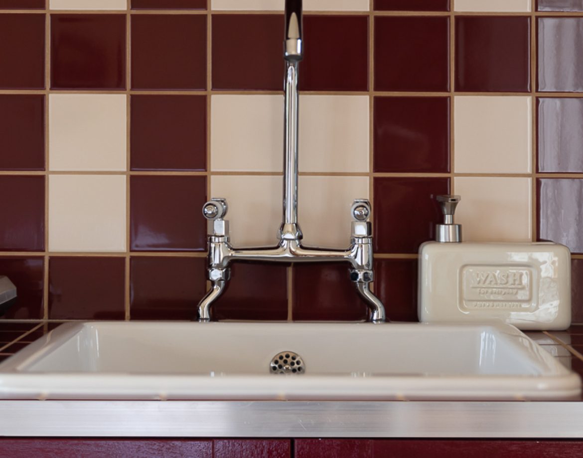 Évier vintage dans un hébergement insolite en Aquitaine, carrelage bicolore élégant.