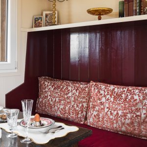 Hébergement insolite en Aquitaine : coin repas cosy avec coussins fleuris et vaisselle élégante.