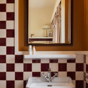 Salle de bain dun hébergement insolite en Aquitaine, carrelage bicolore élégant.